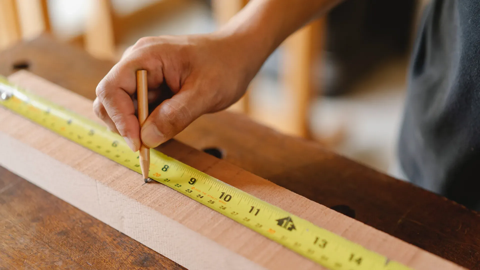 Hombre midiendo un trozo de madera con una regla